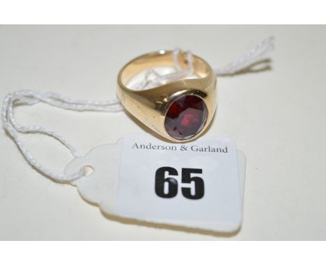 A synthetic ruby ring, the oval facet cut synthetic ruby in collet mount, on yellow metal shank stamped '10K'.