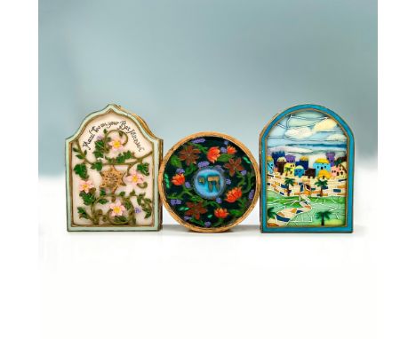 Three painted trinket boxes decorated with multiple different designs, one arc shaped box with a city painted on the cover, o