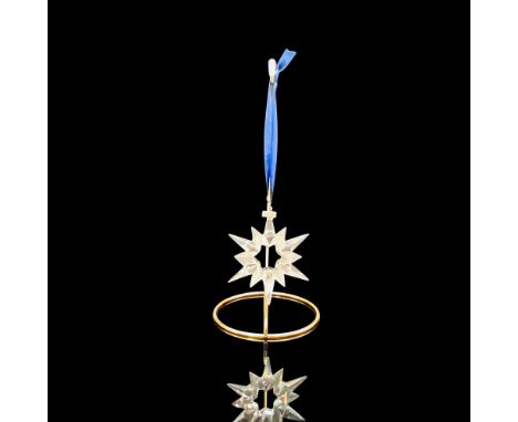 A clear crystal ornament that is in the shape of a star with multiple pointed with a metal key tag that has 1997 imprinted on