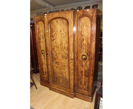 A Victorian walnut and decoupage decorated triple sectioned wardrobe, the interior with fitted shelves and drawers, 193cm hig