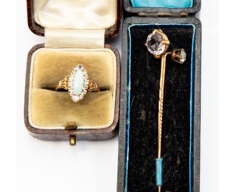 An Edwardian opal and 9ct gold ring, the elongated opal with a border of white stones, size N, along with two stone set pins 