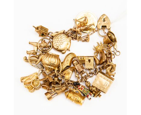 A 9ct gold charm bracelet with various 9ct gold and unmarked yellow metal charms including an 1866 coin, Cuckoo clock, poodle