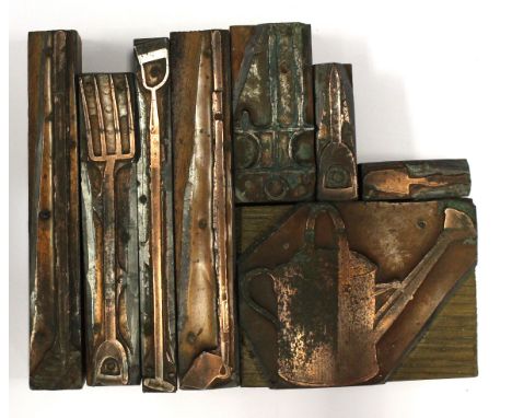Eight copper mounted wood printing blocks, to include watering can, trowel, fork etc early 20th Century 