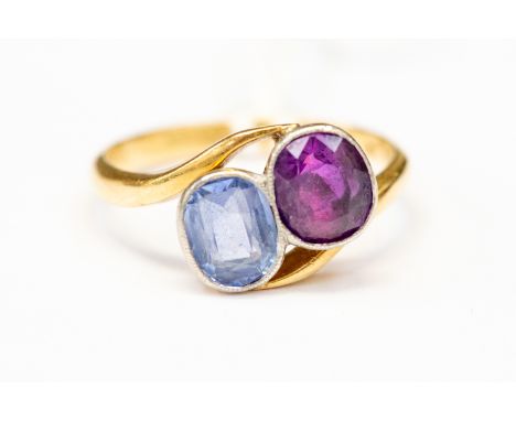 An 18 ct gold ruby and sapphire ring, cross over design with rubover set stones, size K, total gross weight approx 3gms