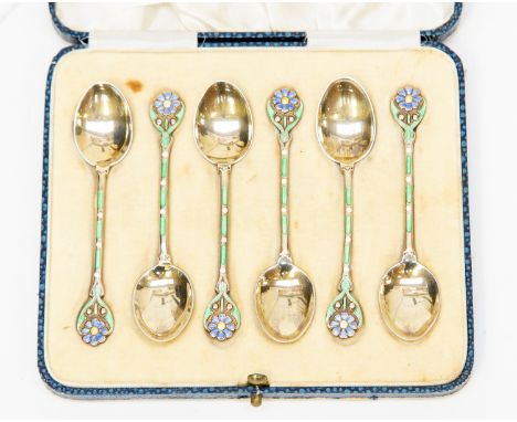 A set of six George V silver-gilt and enamel teaspoons, the terminals set with blue flowers (forget-me-nots), the stems punct