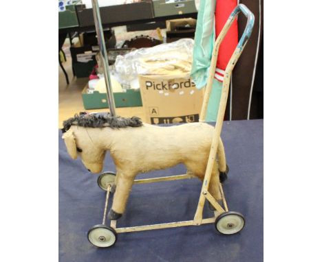 A vintage push along horse on wheels.