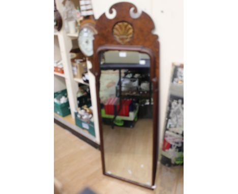 A Georgian style mahogany framed mirror, broken pediment above gilt carved rocaille panel, mirrored panel within raised borde