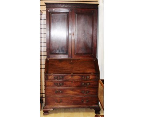 A George III mahogany bureau bookcase, the upper section with a blind fretwork frieze and dentil moulded edge, having two rai