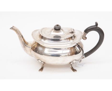 A George V silver oval shaped  teapot, on four shell and hoof feet, the hinged cover with ebonised pagoda finial, ebony C-scr