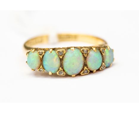 A Victorian opal and diamond set ring, five graduated oval opals set to the top with alternate diamond accents, 18ct gold mou