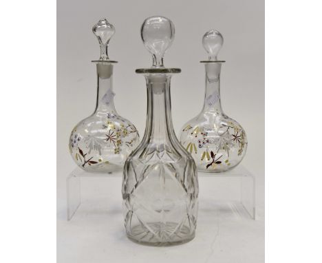 A pair of hand blown decanters with enamel floral design (19th Century) together with an English cut glass decanter 20th Cent