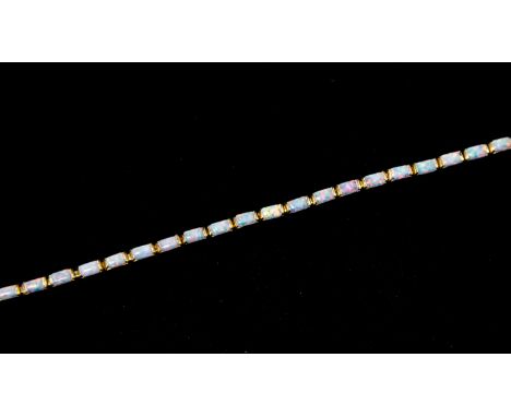 An opal and unmarked yellow metal bracelet, set with 23 lozenge shaped opals, with a pink and green play of colour, stones ap