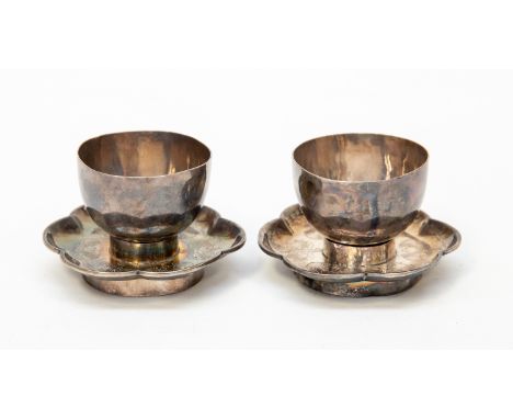 A pair of early 20th Century Chinese egg cups and stands, decorated with engraved bats and twirling foliage