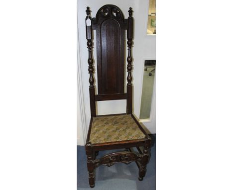 A William and Mary joined oak backstool, the back with a carved crest rail, turned uprights and central panel, padded seat, s