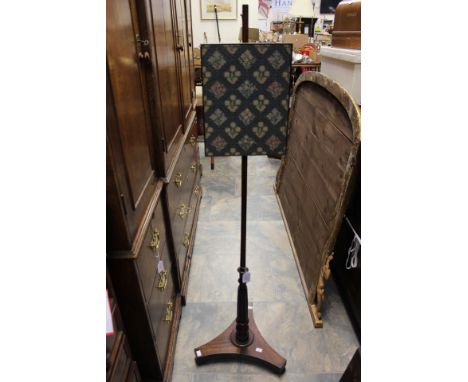An early 19th Century rosewood pole screen, woolwork panel, turned and reeded column, standing on a concave triform base, ros
