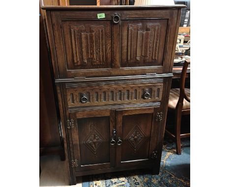 A Jacobean style oak drinks cabinet with fall front cocktail section, drawer and double cupboard under 