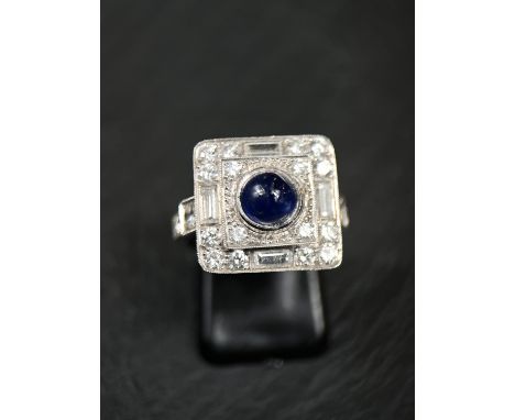 A sapphire and diamond Art Deco cocktail ring with central cabochon sapphire surrounded by 16 brilliant cut diamonds and 4 ba