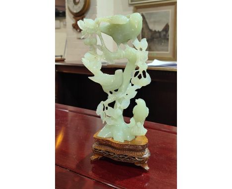 A Chinese jade coloured hard stone carving of three birds sat on branches, well detailed with hanging leaves and fruit, with 