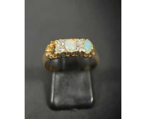 An 18ct gold dress ring set with four diamonds and two opals (gap for a 3rd missing) 3.7gm M/N 