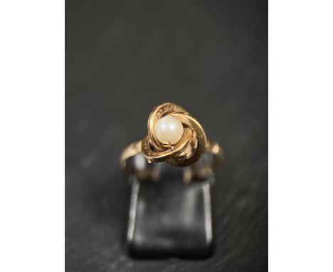A pearl ring in knot style setting, foreign marks, tests 14ct+, 1.4gm, size N 