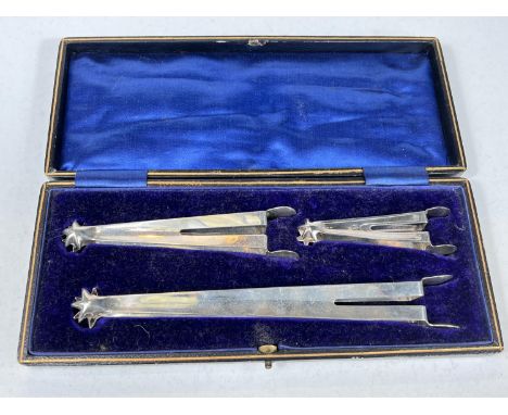 A cased set of three sugar nips, two hall marked silver one unmarked, graduating in size Chester 1925