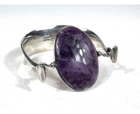 Georg Jensen:designed by Vivianna Torun Bulow-Hube, a silver bangle with central oval polished amethyst in a tension clamp se