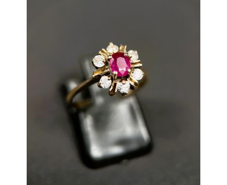 An 18ct gold dress ring, flowerhead setting with central ruby size L, 2.9gm 