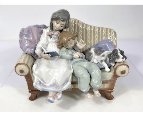 A Nao group:&nbsp; girl on sofa reading to younger girl, with dog, No 5735 