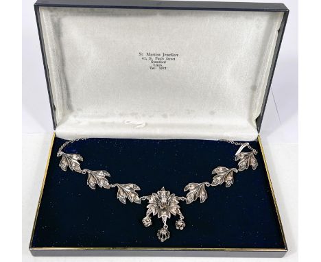 A Victorian silver and gold necklace with 3 leaf shapes set with diamonds to either side of central flowerhead with raised ce