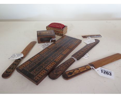 Seven items of Tunbridgeware including three paper knives, cribbage board, pin cushion - some minor losses