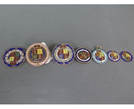Seven enamel finished coins of differing denominations