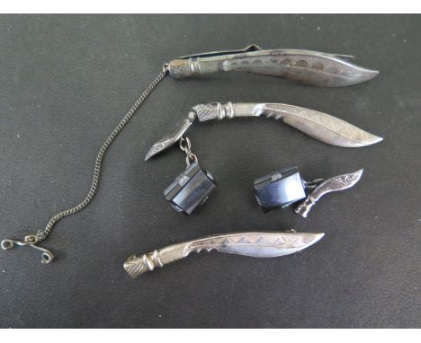 Two Kukri white metal tie clips, a brooch and a pair of cufflinks