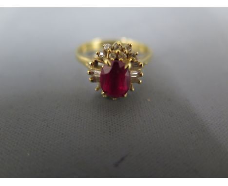 An 18ct yellow gold ring with oval cut ruby to centre surrounded by clear stones - ring size Q/R - usage wear, missing a smal