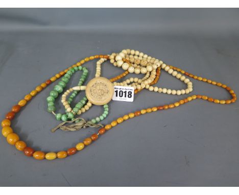 A string of carved bone beads, a string of graduated bone beads, a string of egg yolk amber or faux amber beads - one damaged