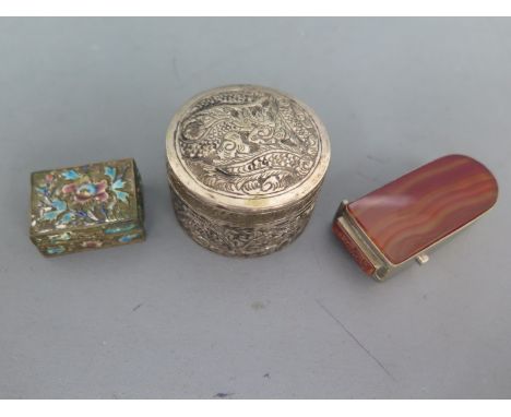 A white metal and enamel patch box with hinged cover, a circular silver trinket box decorated with stylized flora and foliage