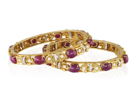 A PAIR OF RUBY AND DIAMOND BANGLESEach openwork bracelet decorated with card deck symbol motifs accented with brilliant and s