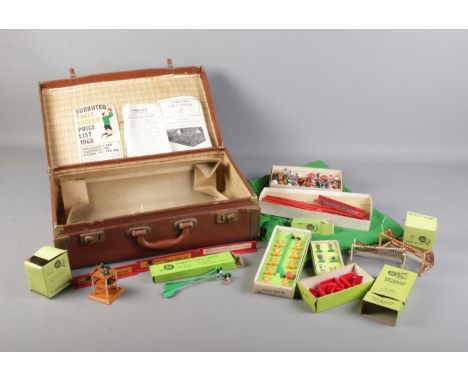 A vintage suitcase with a collection of Subbuteo items inside. To include pitch cloth, fencing, goals, boxed players etc.  