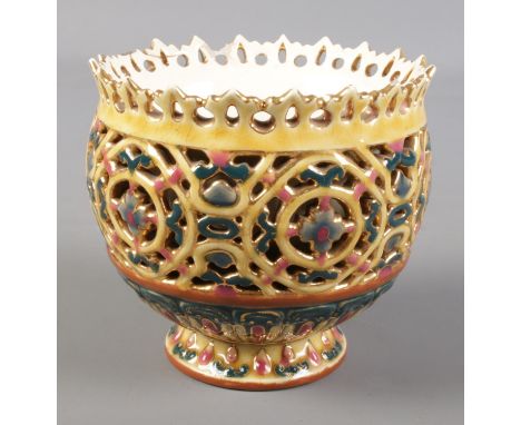 A Zsolnay Pecs reticulated pedestal bowl. Stamped to base 1026.  Chips and cracks around rim.