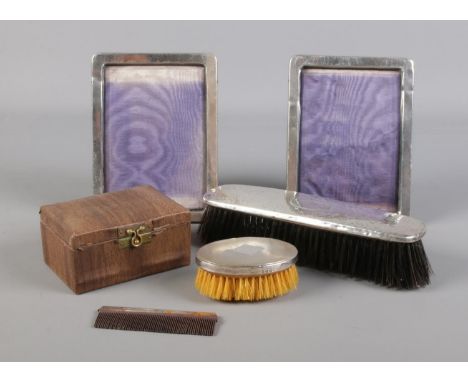 Two silver picture frames, together with a cased silver backed brush and comb set and another silver backed brush. Cased set 