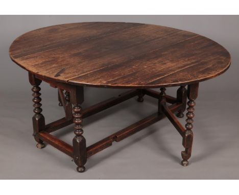 A Georgian oak drop leaf table with single drawer to one end and bobbin turned supports.  