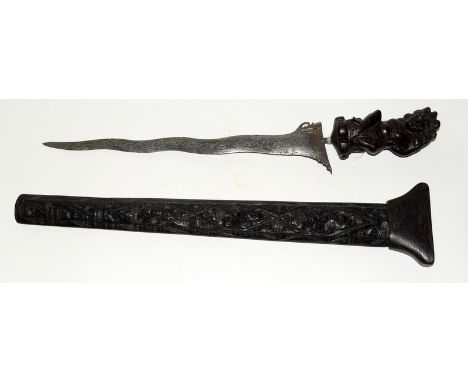 A Southeast Asia Kris with an elaborately carved scabbard and hilt. Blade length 34cms. Overall length including scabbard 62c