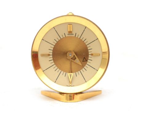 Jaeger A gilt brass travel alarm clock in red box, midcentury, marked to the dial. 5 cm. h.