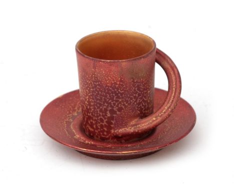 Johan van Loon (1934-2020) A porcelain cup and saucer, copper-coloured with gilt inside, a gift of the artist at the occasion