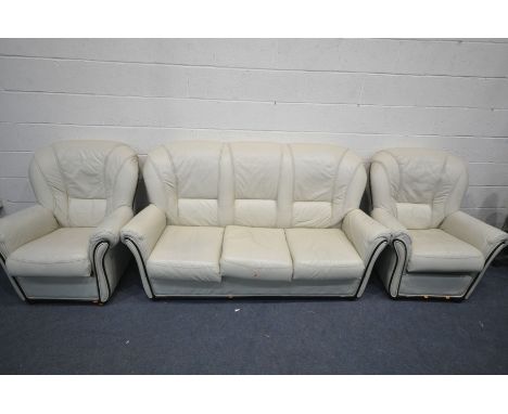 A CREAM LEATHER THREE PIECE LOUNGE SUITE, comprising an three seater sofa, length 180cm, and two armchairs (condition - some 