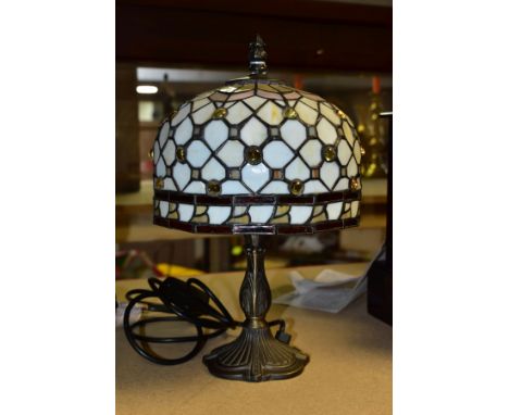 A MODERN TIFFANY STYLE DESK LAMP, a domed shade sits over a bronzed metal base, approximate height 33cm, R.V.A retailers labe