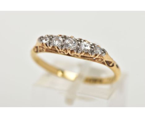 A YELLOW METAL DIAMOND BOAT RING, set with five graduated round brilliant cut diamonds, scroll detailed gallery and shoulders