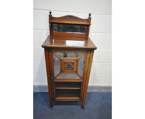 AN EDWARDIAN WALNUT MUSIC CABINET, with a mirrored raised back with a shelf, a single door with four bevelled mirror sections