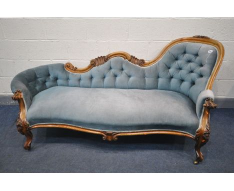 A VICTORIAN WALNUT CHAISE LONGUE, with pale blue upholstered button back, within a foliate and scrolled frame, length 198cm