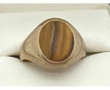 A men's 9ct gold signet ring set with a oval shaped  Tigers Eye stone. Total weight approx. 4.4g. Ring size O½. 