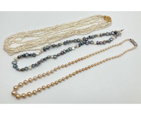 3 freshwater pearl and faux pearl necklaces. A multi strand baroque pearl necklace with decorative gold tone clasp, a peacock